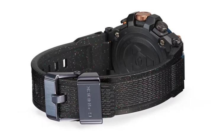 手表表带以混合多彩微粒铝素材的黑色软质树脂制成，金属表带扣环与表壳一样经过蓝色和紫色IP处理。
